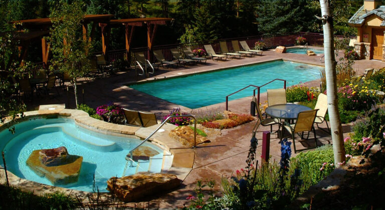 antlers at vail pool area with vail mountain in background and gore creek running by it