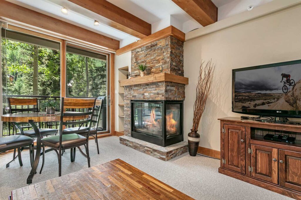 View of fireplace, dining table, balcony condo 108 Antlers at Vail