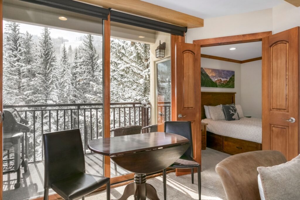 View of dining area, balcony, bedroom condo 303 Antlers at Vail