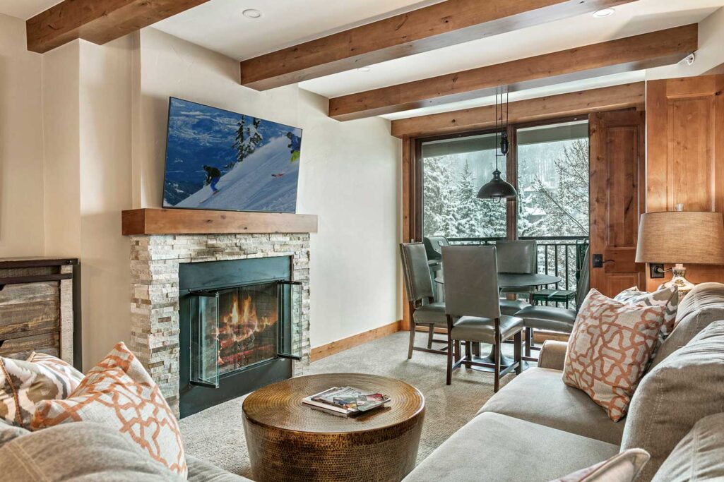 Living and dining areas of Antlers at Vail condominium 507 with a cozy fire in the gas fireplace