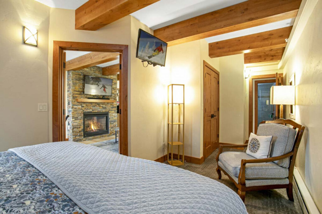 View of bedroom and the fireplace in the living room of condo 602 Antlers at vail
