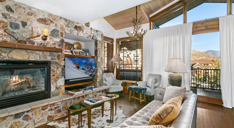 living room with warm gas fireplace in antlers at vail residence 620, with views of lionshead and the gore range