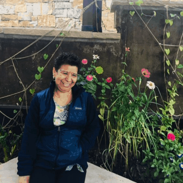 Antlers housekeeper Bertha Romero in front of flowers