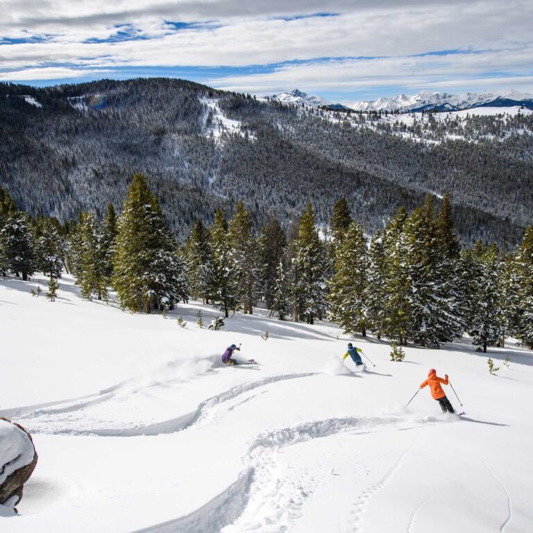 skiers making fresh tracks in blue sky basin