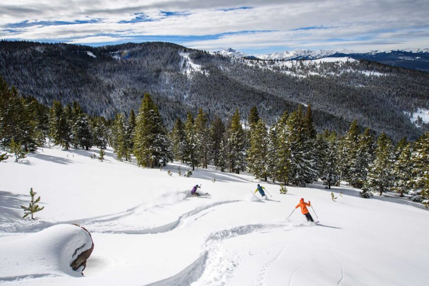 skiers making fresh tracks in blue sky basin