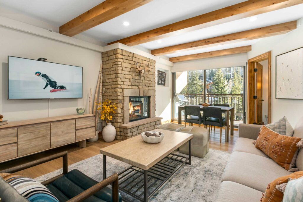 Living area of Antlers at Vail condo 311 with large sliding glass doors overlooking mountain and pool