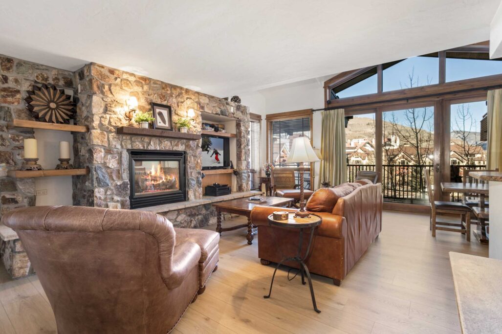 living room of antlers at vail 4 bedroom residence 519, with cozy gas fireplace and large windows towards the gore range