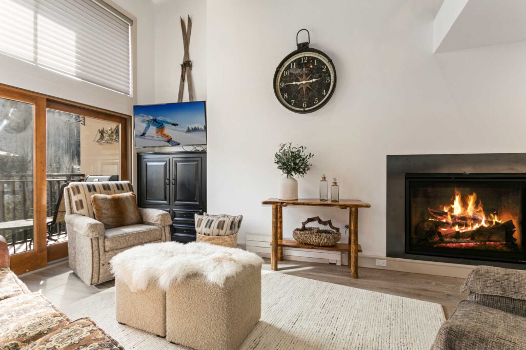 Living room of Antlers 3 bedroom condo 704 with cozy gas fireplace and large sliding glass door with mountain and river views