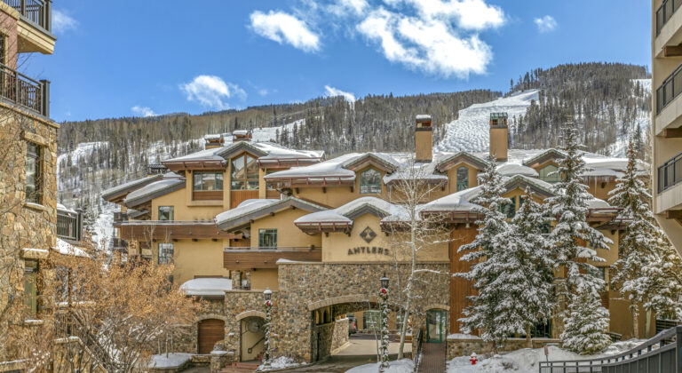 front of antlers at vail hotel with ski slopes in background