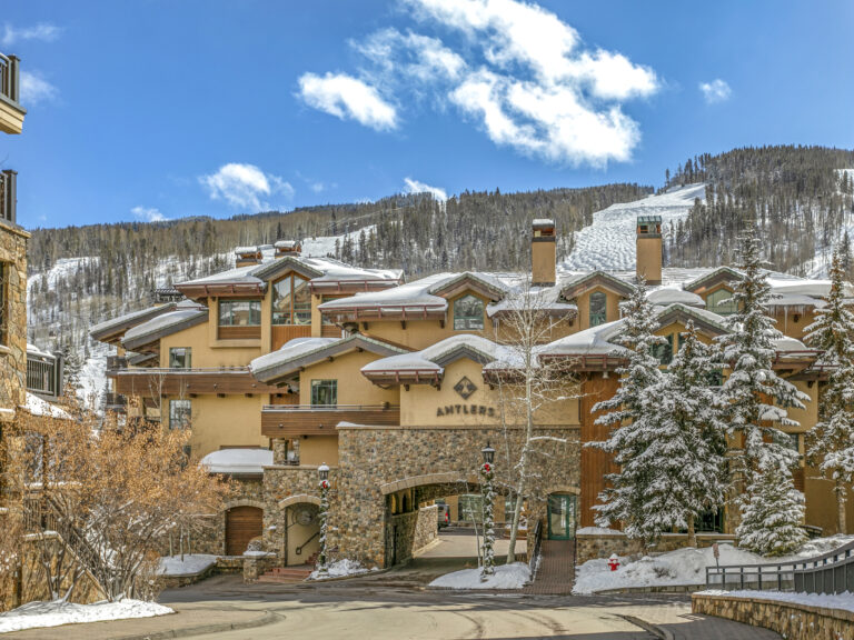 front of antlers at vail hotel with ski slopes in background