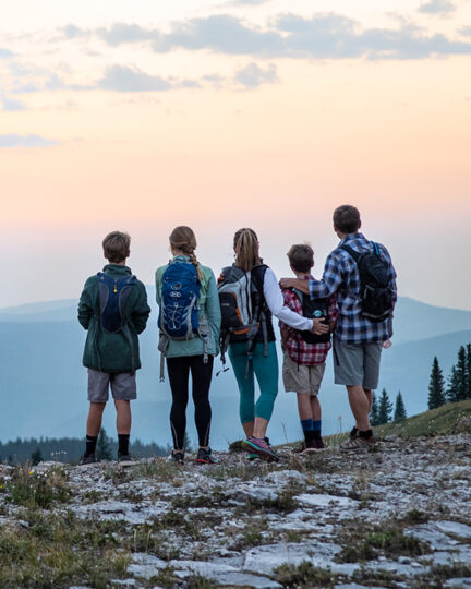 Family of 5 overlooking mountain vista at sunset