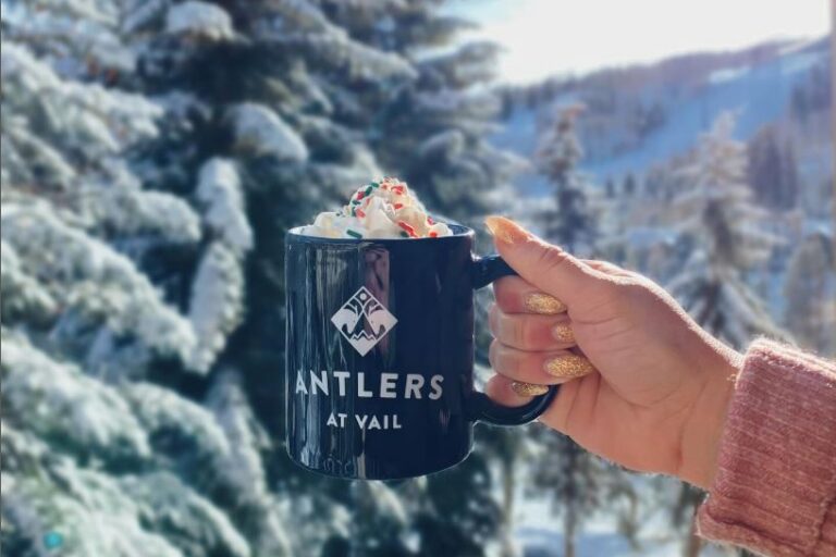 Antlers coffee mug with backdrop of snowy mountains