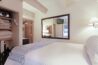 Bedroom in Antlers at Vail condo 502 with queen bed, open closet with linens, large wall mirror, and wall-mounted TV