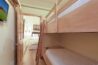 Bunk room in Antlers at Vail condo 502 with twin-over-twin wood bunk beds, wall-mounted TV, and open doorway to adjacent bedroom