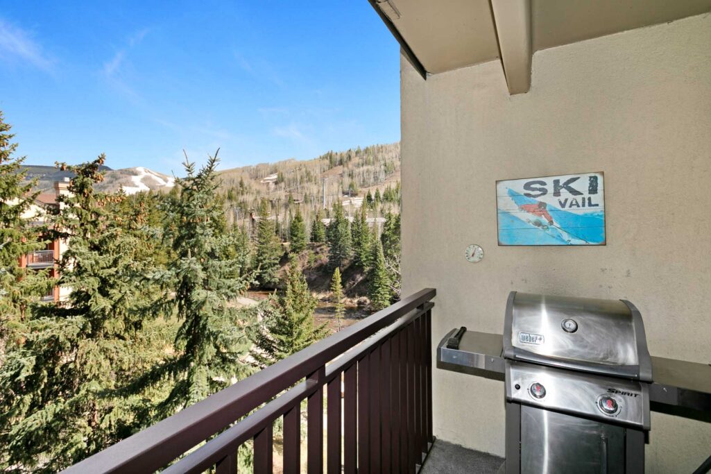 Balcony of Antlers at Vail condo 502 with Weber Spirit gas grill, Ski Vail sign, and views of snow-dusted Vail Mountain slopes