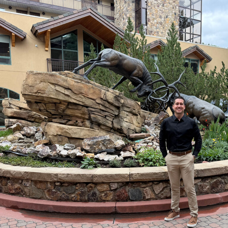 Antlers new housekeeping manager in fromt of Antler's building and elk statue
