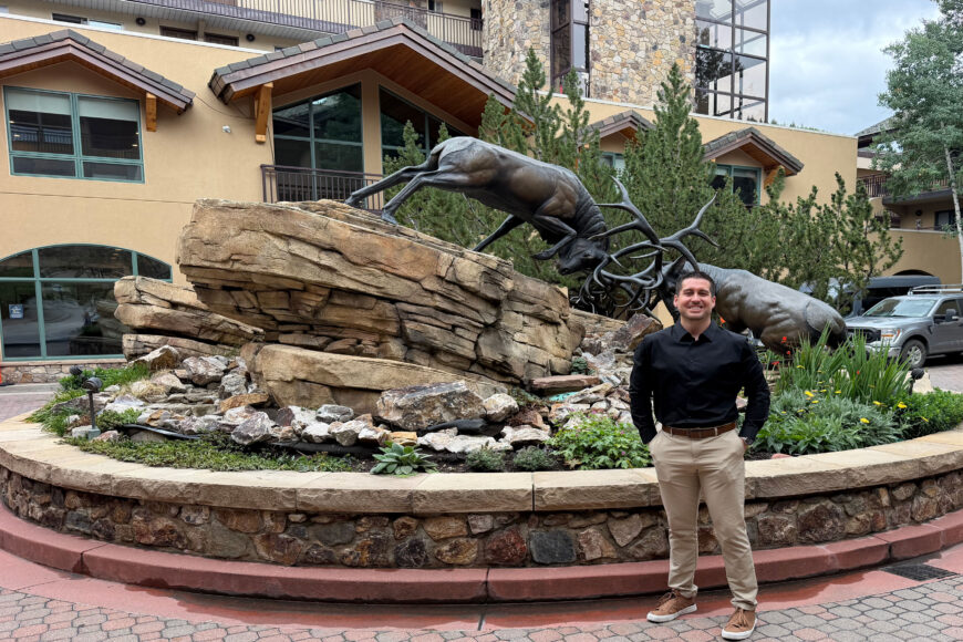 Antlers new housekeeping manager in fromt of Antler's building and elk statue